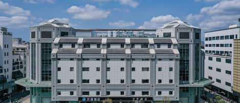 A modern hotel with a symmetrical facade, large windows, and a prominent entrance.