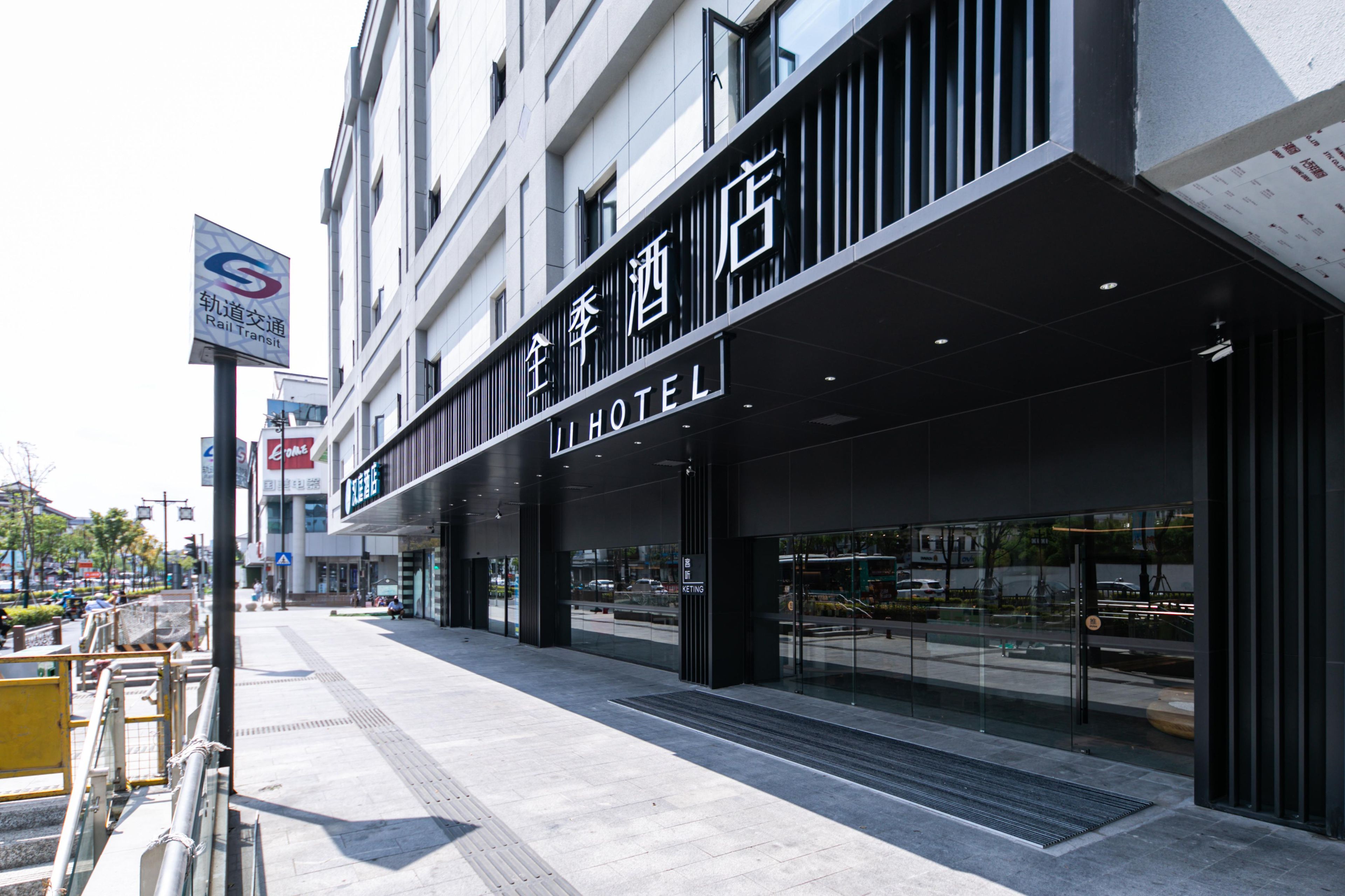A hotel with a modern facade, large glass windows, and a sign indicating it is a hotel.