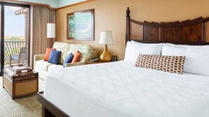Una habitación de hotel con una cama grande, un sofá, una lámpara y un cuadro en la pared.