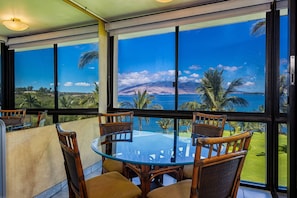 Relax in comfort with a panoramic view of the tropical landscape from this room's expansive windows.