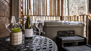 Ein Tisch mit einer Flasche Whitehaven Sauvignon Blanc, zwei Weingläsern und einem kleinen Topfpflanzen in einem überdachten Außenbereich.