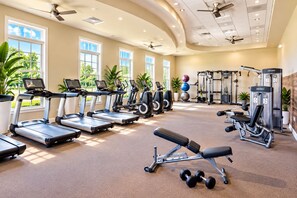 A gym with treadmills, weight machines, and dumbbells.