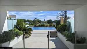 A pathway leading to a swimming pool with a sign indicating pool hours.