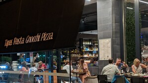 A restaurant with a sign reading "Tavas Pasta, Gnocchi, Pizza."