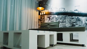 A reception area with a modern design, featuring a white reception desk, a leather chair, and a cityscape mural on the wall. - 1 BR- INSPIRIA RESIDENCE CONDOMINIUM, Abreeza Mall,  Bajada, Davao City. (Davao City)