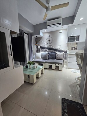 A modern living room with a sofa, a coffee table, and a TV. - 1 BR- INSPIRIA RESIDENCE CONDOMINIUM, Abreeza Mall,  Bajada, Davao City. (Davao City)