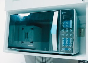 Een Whirlpool magnetron met een digitaal display, bedieningspaneel en kinderbeveiliging.