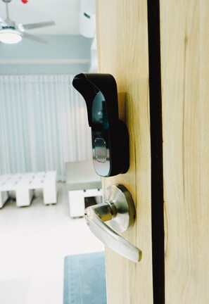 Una puerta moderna con una cerradura electrónica negra y un picaporte plateado.