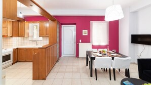 A modern kitchen with wooden cabinets and a dining area with a table set for four. - Aria 2 - Vacation apartment in Crete, 100 m from the seaside (Kolimbári)