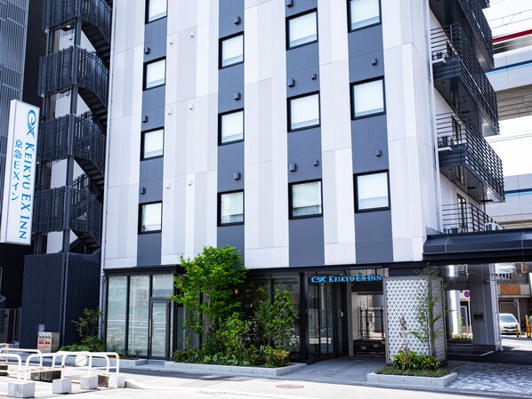 Een modern hotel met een verticale gevel, grote ramen en een opvallende entree.