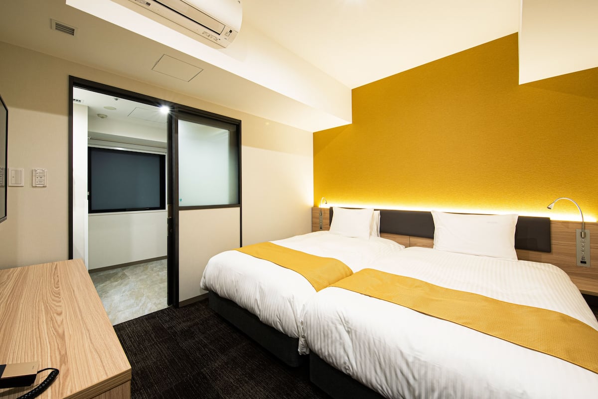 Une chambre d’hôtel comprenant un lit, un bureau et une porte coulissante donnant accès à la salle de bain.