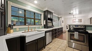 A kitchen with a large window, stainless steel appliances, and a white countertop. - Family Retreat, outdoor oasis, game room (Broken Bow)