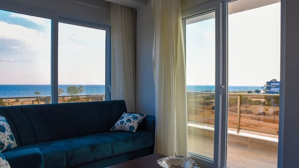 A balcony with a view of the sea and a building. - Soral Apart Otel (Demre)