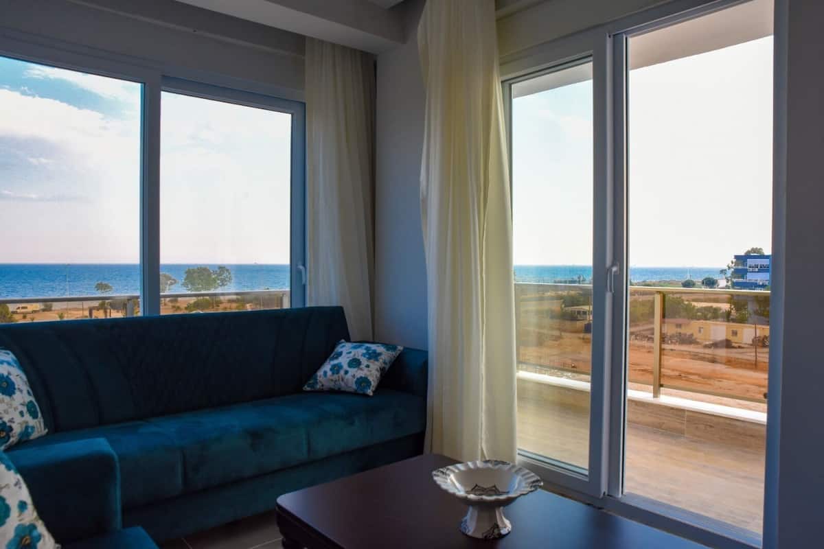A balcony with a view of the sea and a building.