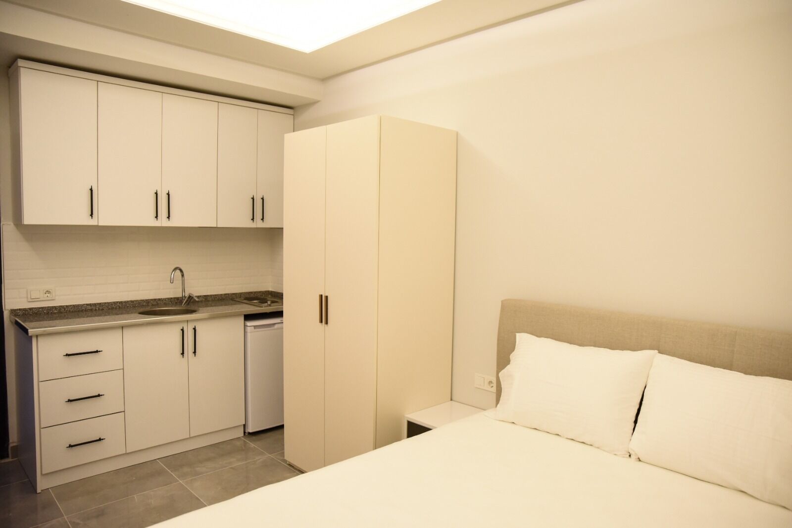 Un dormitorio con cama, mesita de noche y armario.