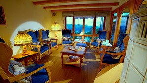 A cozy room with wooden furniture, a chessboard, and a view of the outdoors. - Double room Buschwindröschen (vacation hotel) - Belvedere-Bio-Hotel garni & Suite (Waldeck)