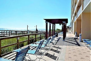 Relax on the ocean-view deck with lounge chairs and a wooden railing.