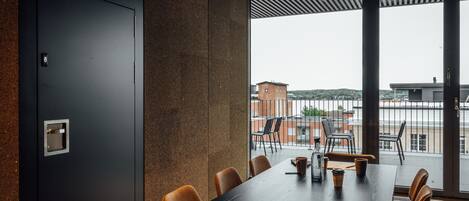 A conference room with a long table, chairs, and a view of the city through large windows.