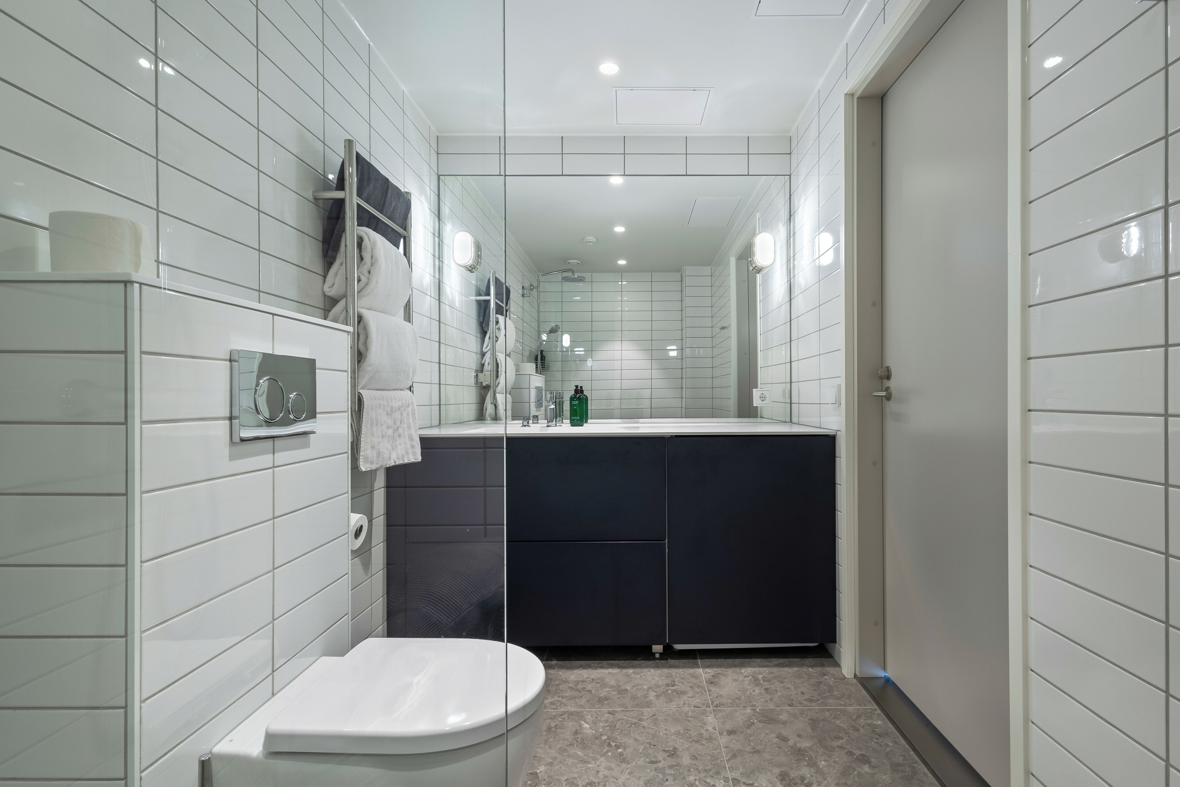 Un baño moderno con inodoro, lavamanos y zona de ducha.