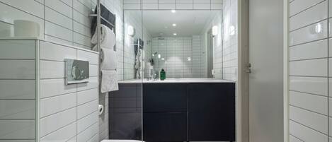 A modern bathroom with a toilet, a sink, and a shower area.