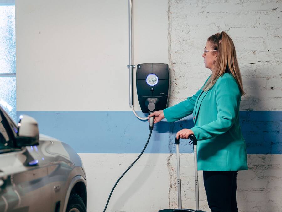 Una persona sta caricando un'auto in un parcheggio coperto.