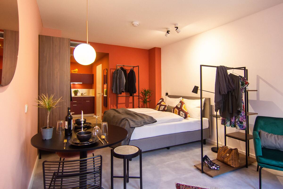 Une chambre moderne avec un lit, une table de chevet et un portant à vêtements.