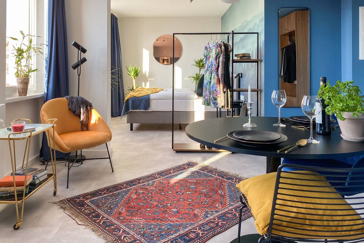 Une chambre à coucher moderne avec un lit, une table de chevet et une grande fenêtre.