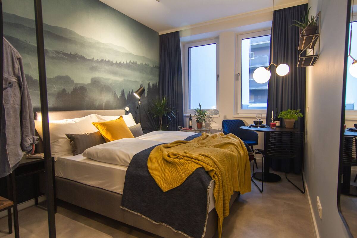 Une chambre d’hôtel moderne équipée d’un lit, d’un bureau et d’un coin repas.