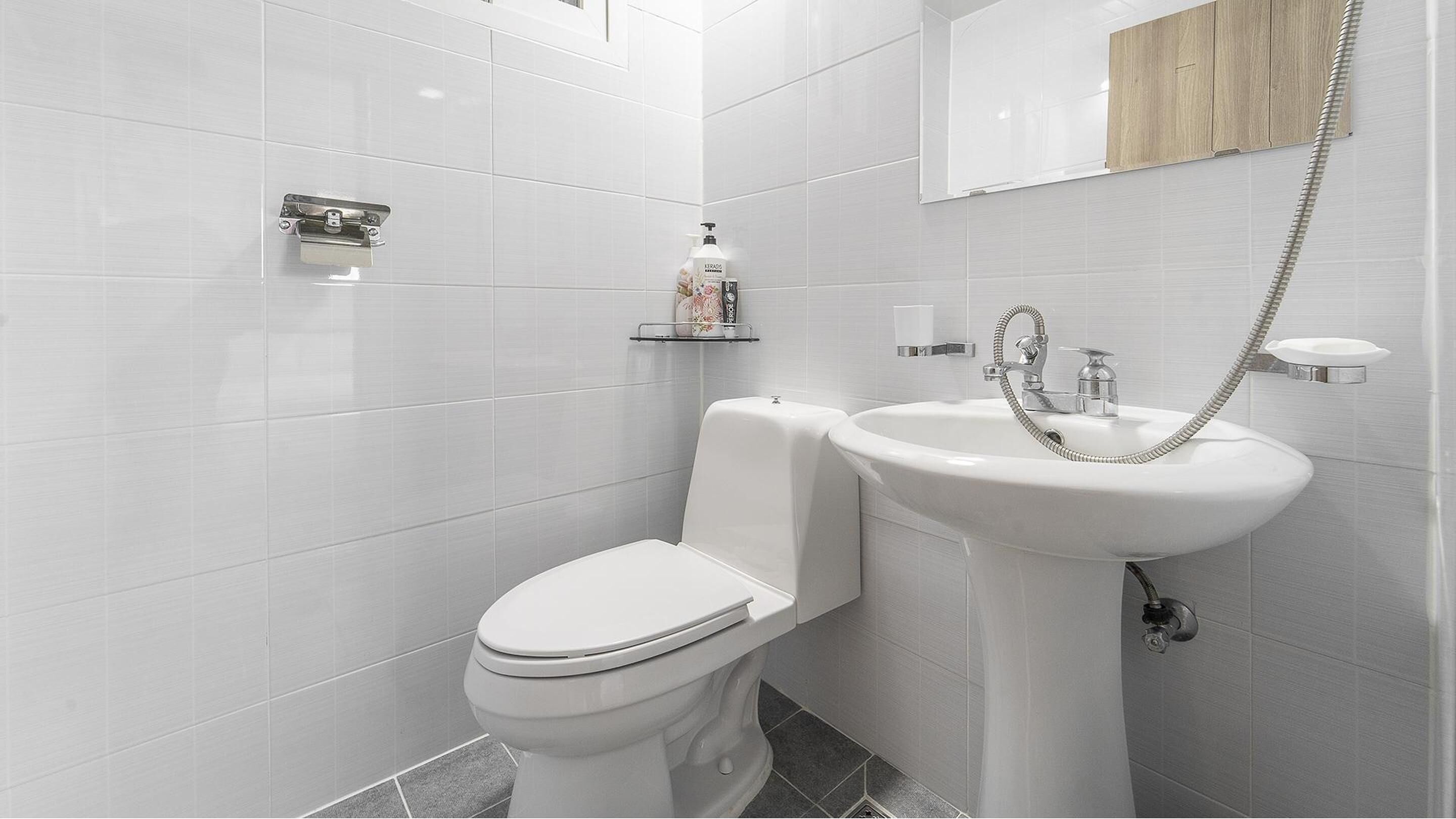 A modern bathroom with a toilet, sink, and shower.
