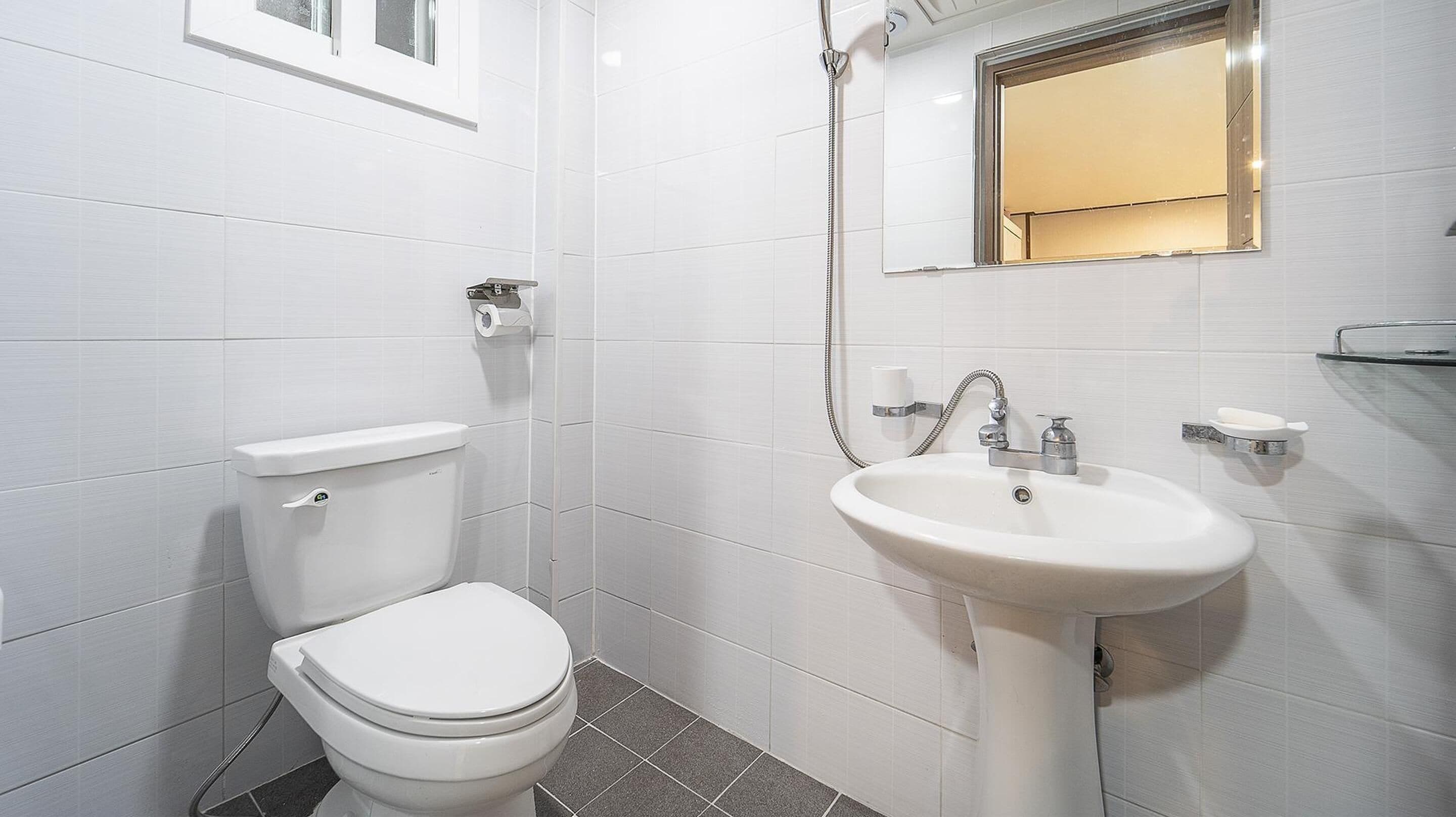 A modern bathroom with a toilet, sink, and shower.