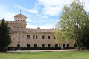 A stone building with a tiled roof and a small tower. - Hotel Monasterio de Tejeda (Garaballa)