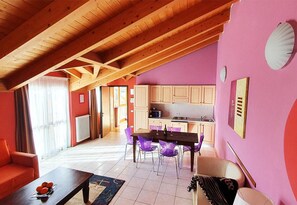 Cozy living area with a high ceiling, dining space, and modern kitchen.