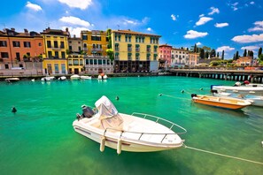 Stroll along the tranquil waterfront, surrounded by historic buildings with charming balconies and picturesque piers.