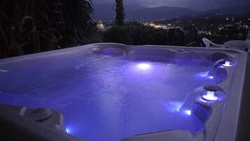 Un jacuzzi con vistas a un paisaje urbano nocturno.