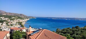 A coastal town with terracotta-roofed buildings, a clear blue sea, and a hilly backdrop. - Mili's House SeaView - Kalyves (Apokoronas)