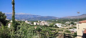 A residential area with houses, a mountain range in the background, and a clear sky. - Mili's House SeaView - Kalyves (Apokoronas)