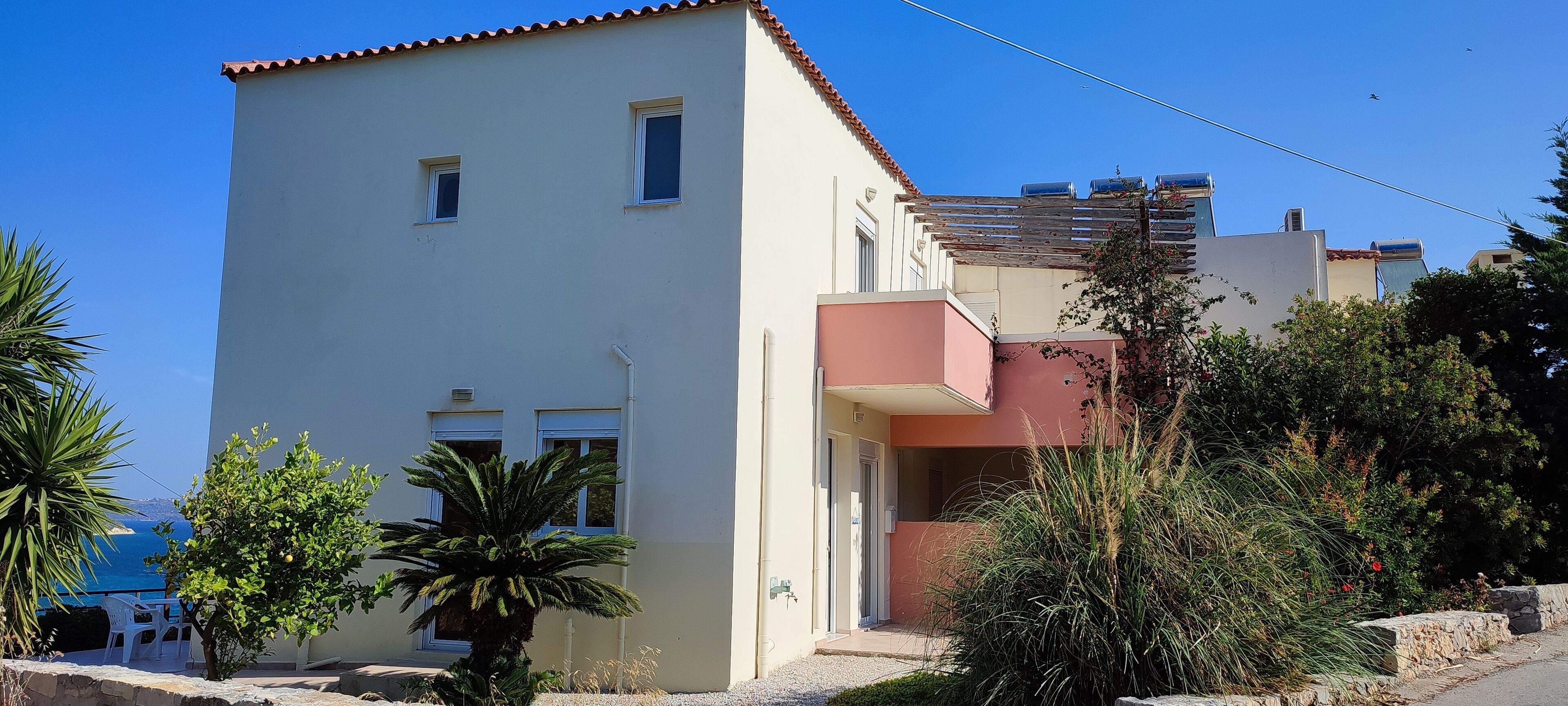 Un edificio de dos pisos con un balcón, una puerta y una ventana.