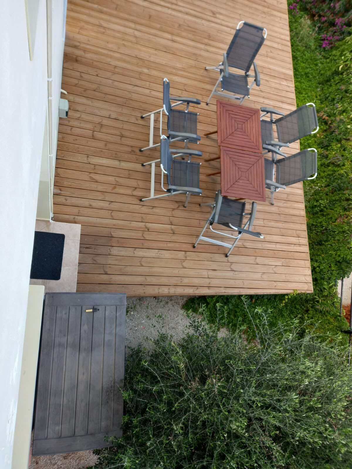 Une terrasse en bois avec une table et six chaises.