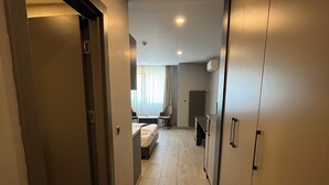 Corridoio di un hotel con un letto, una scrivania e un armadio.