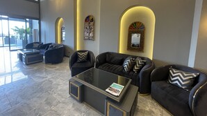 Una hall moderna con un divano, un tavolino da caffè e uno specchio decorativo.
