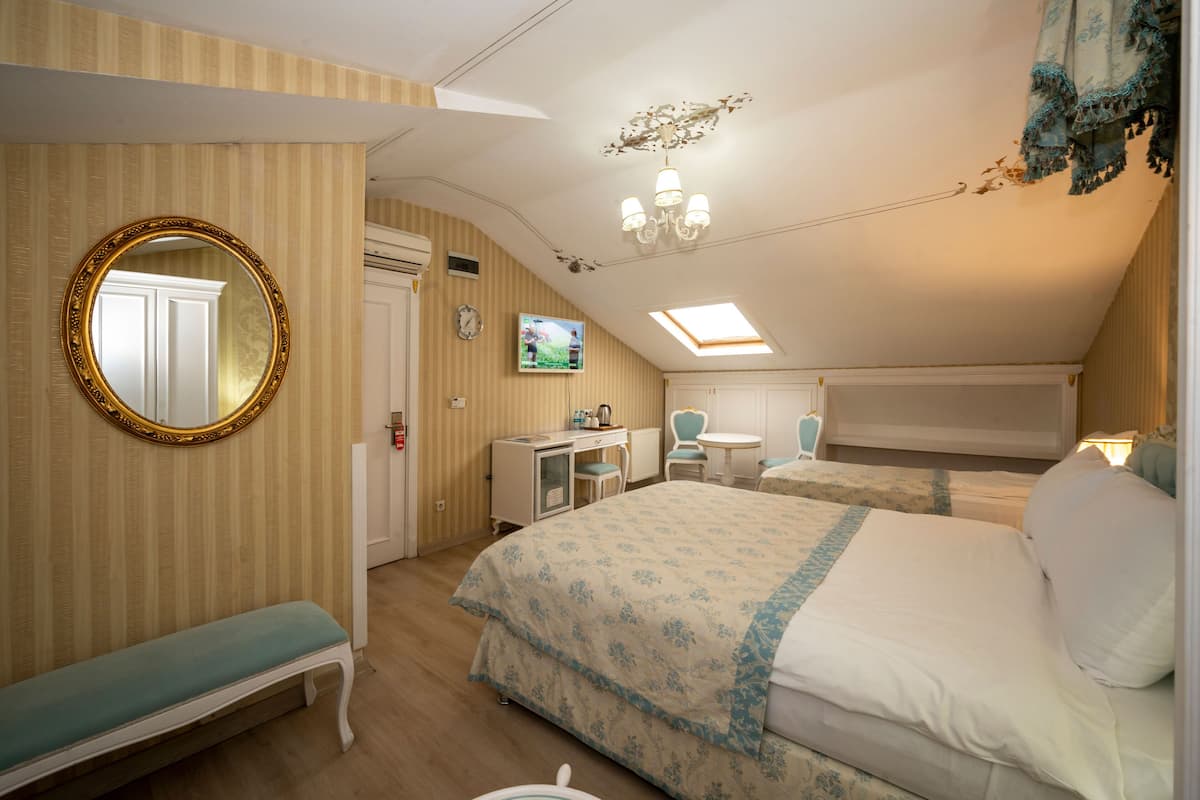Une chambre à coucher comprenant un lit, un bureau, une chaise, un banc, une télévision et un miroir.