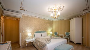 A hotel room with a large bed, two bedside tables with lamps, a wardrobe, and a chandelier. - Villa Paradiso & Spa Hotel (Istanbul)