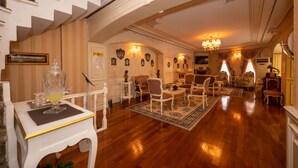 A spacious living room with a wooden floor, a staircase, and a chandelier. - Villa Paradiso & Spa Hotel (Istanbul)