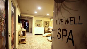 A hallway leading to a spa area with a tiled floor, a reception desk, and a wall with 'LIVEL WELL SPA' text. - Villa Paradiso & Spa Hotel (Istanbul)