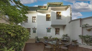 A two-story building with a balcony, potted plants, and a wooden deck with wicker furniture. - Villa Paradiso & Spa Hotel (Istanbul)