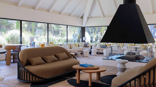 Um interior moderno com sofá, mesa de centro e uma grande luminária pendente preta.