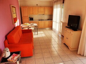 Appartamento familiare, 1 letto matrimoniale con divano letto, lato giardino (Garda Palace 4) | Area soggiorno | Smart TV