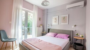 A bedroom with a bed, a chair, a bedside table, and a radiator. - Valeria Sea View Apartment in Rethymno, Crete (Rethymno)
