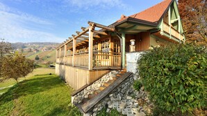Une maison en bois avec un escalier en pierre menant à une terrasse en bois.