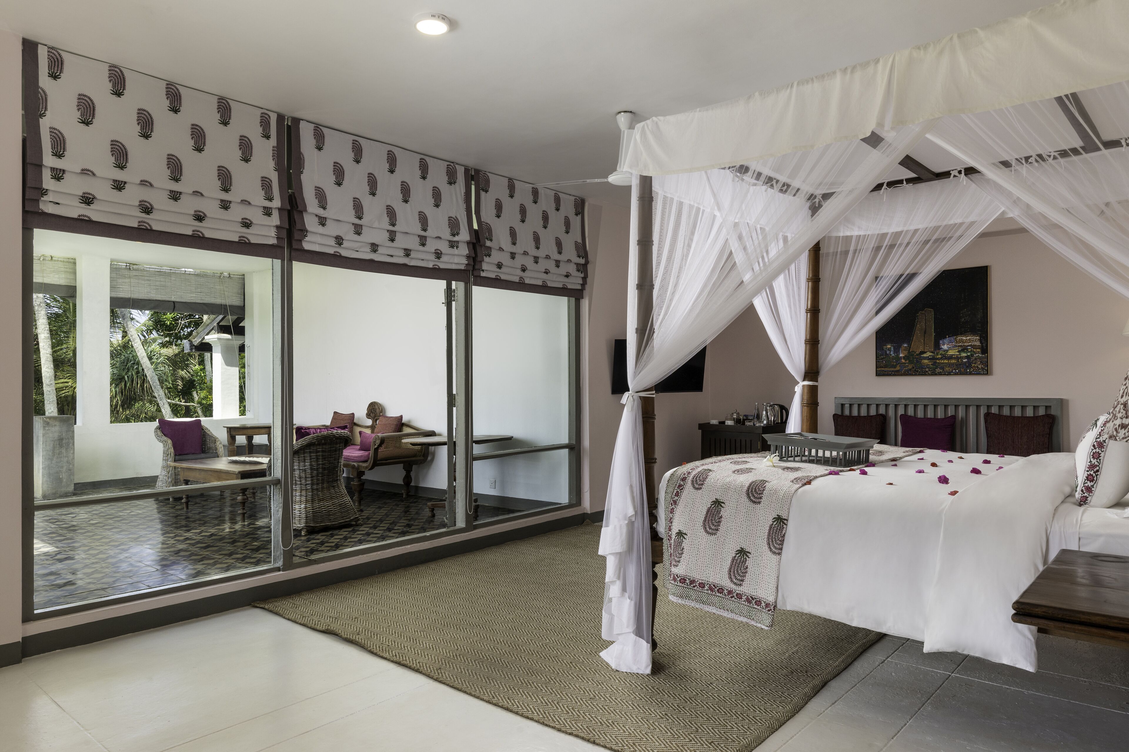 Un dormitorio con cama con dosel, ventanas amplias y vistas al exterior.
